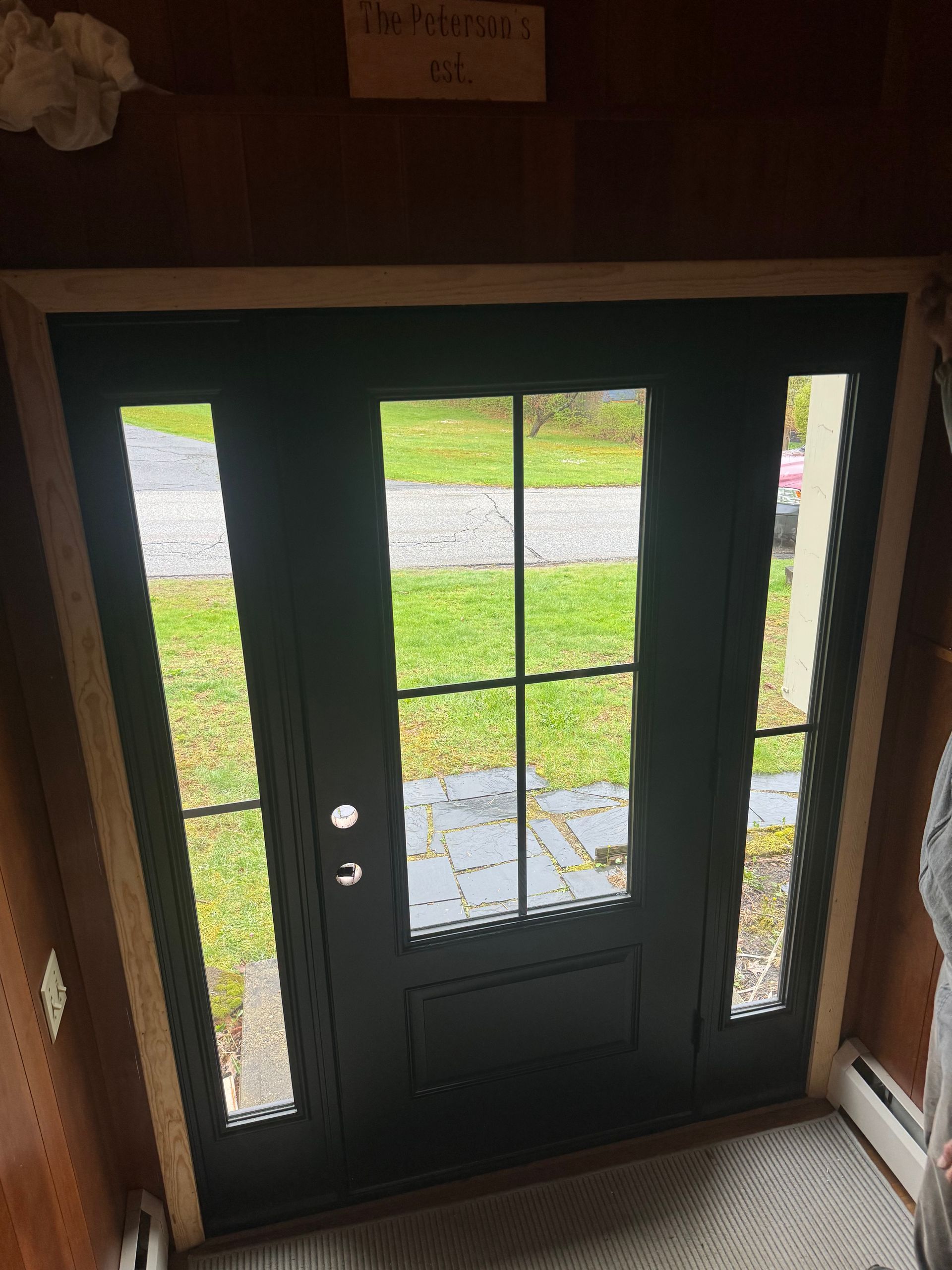 A person is standing in front of a black door.