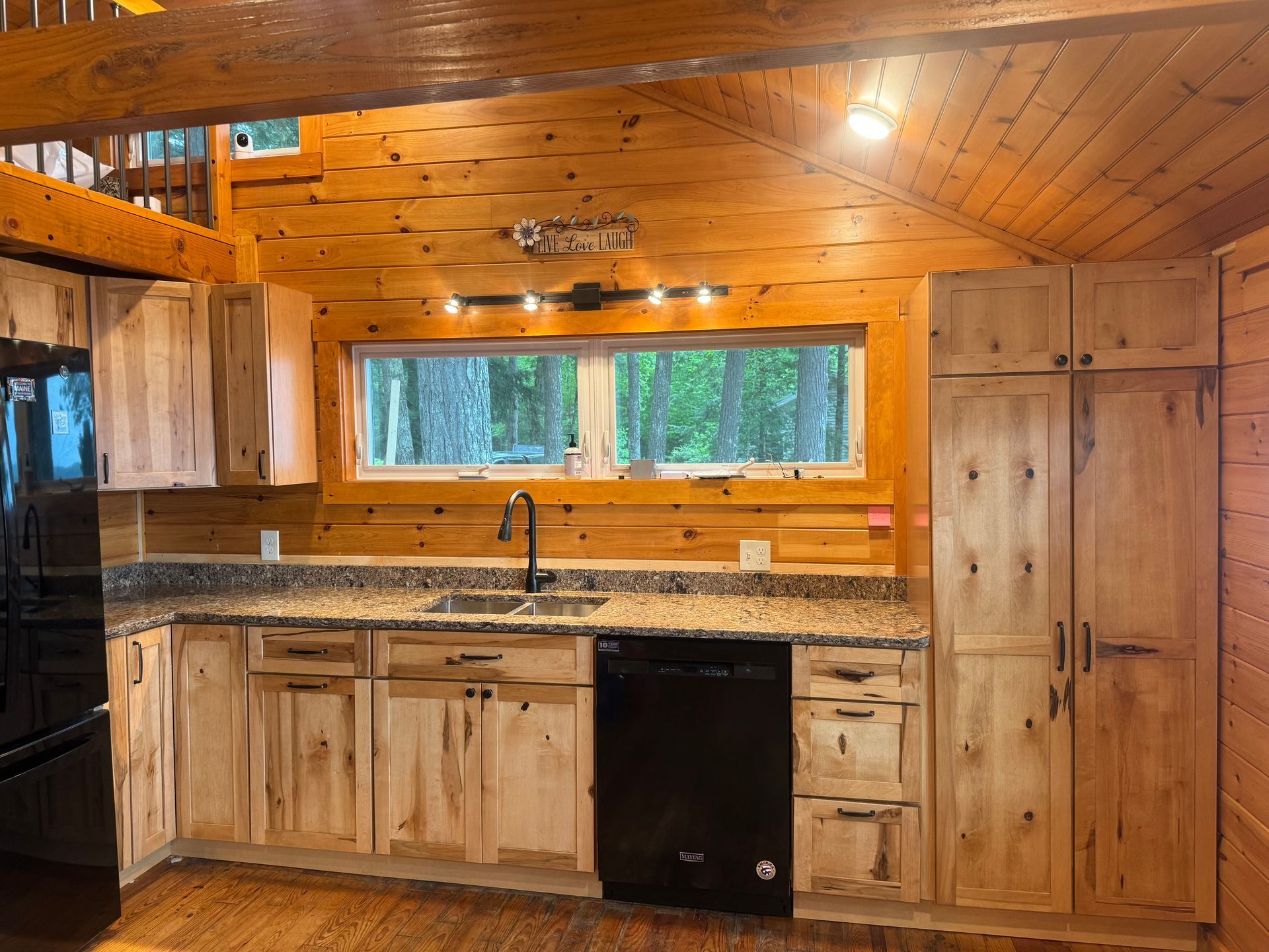 A kitchen in a log cabin with wooden cabinets and granite counter tops