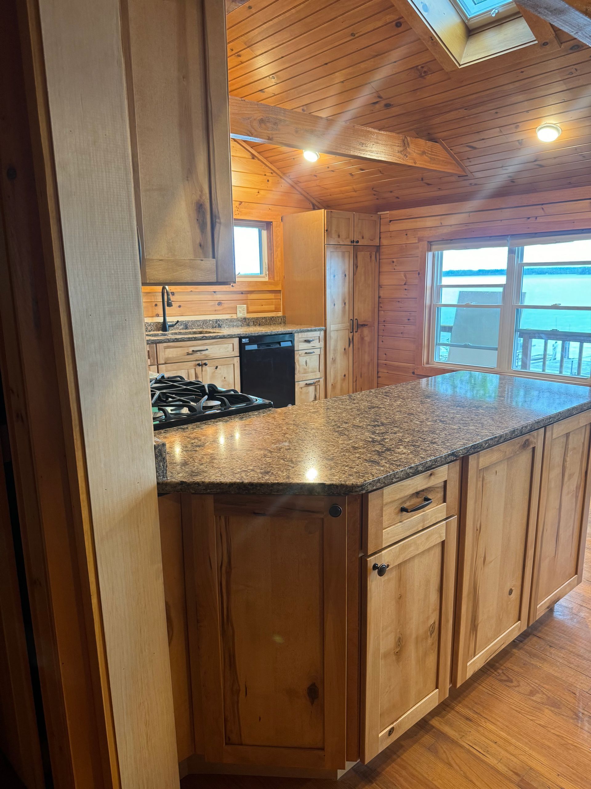 A kitchen with wooden cabinets and a granite counter top.