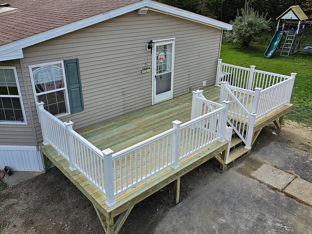 An aerial view of a mobile home with a large wooden deck.