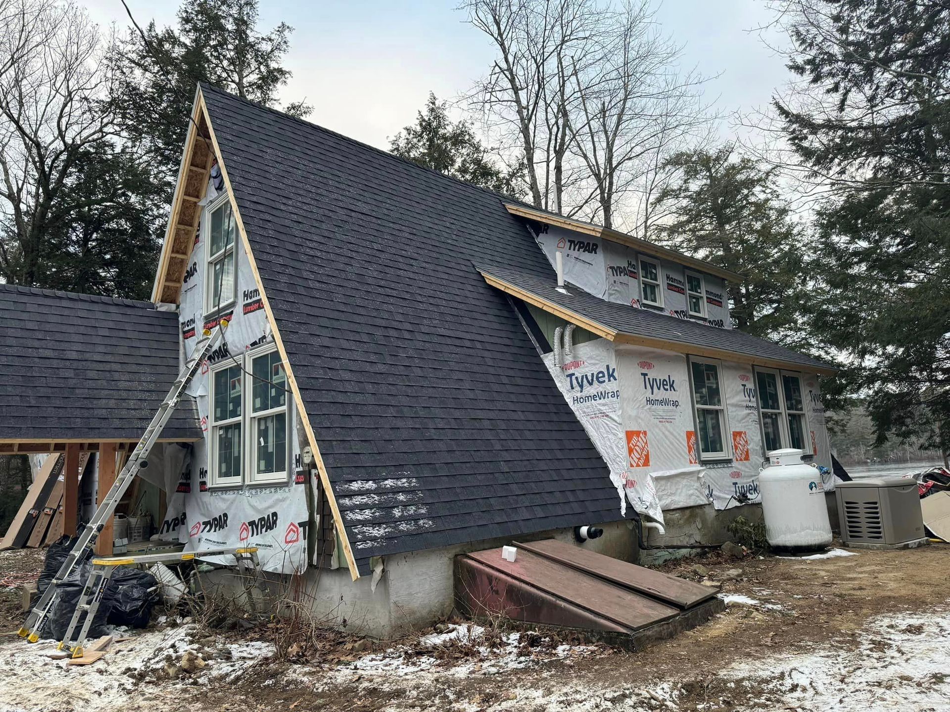 A house with a roof that is being built in the snow.