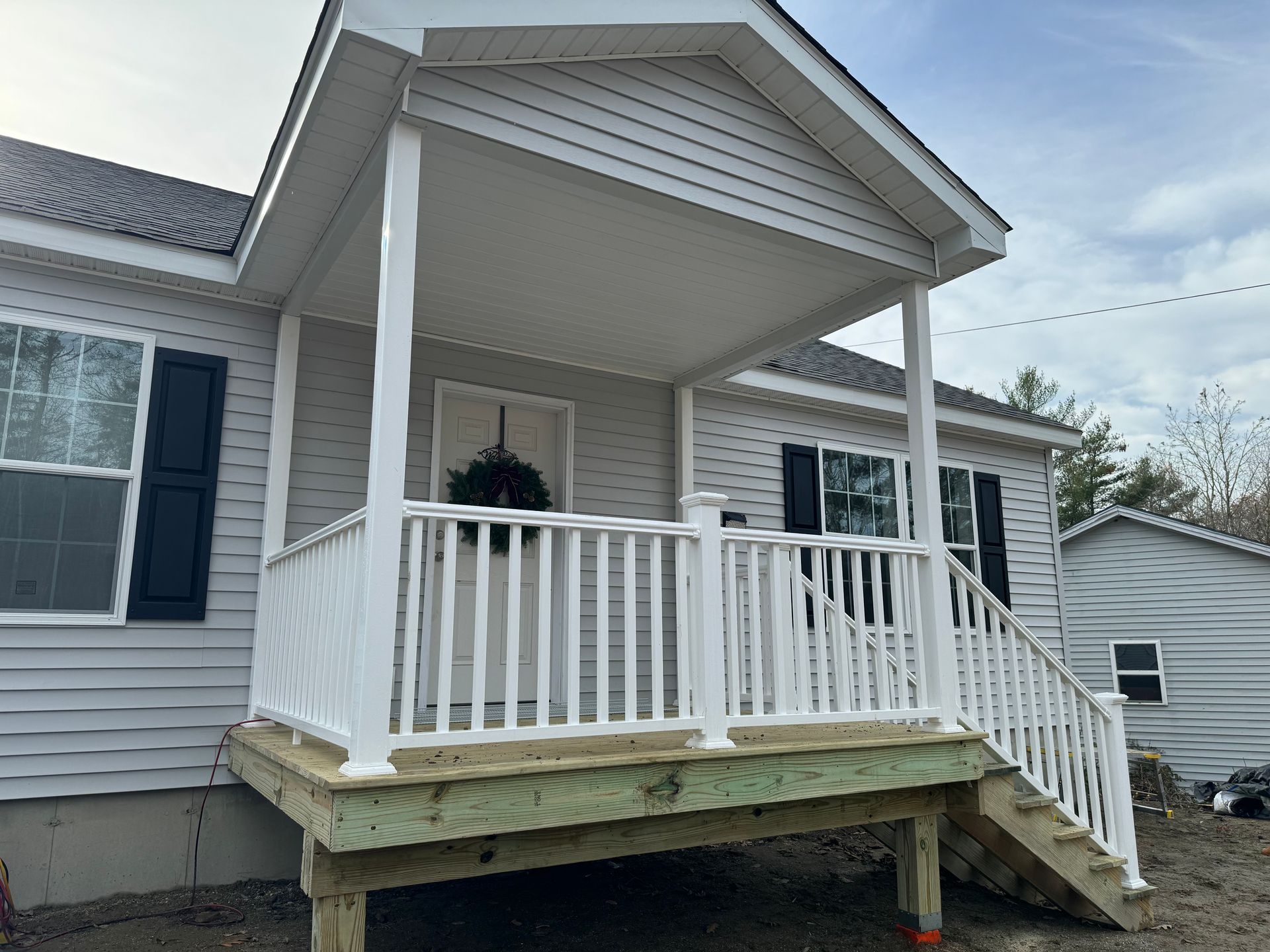 A white house with a porch and stairs.