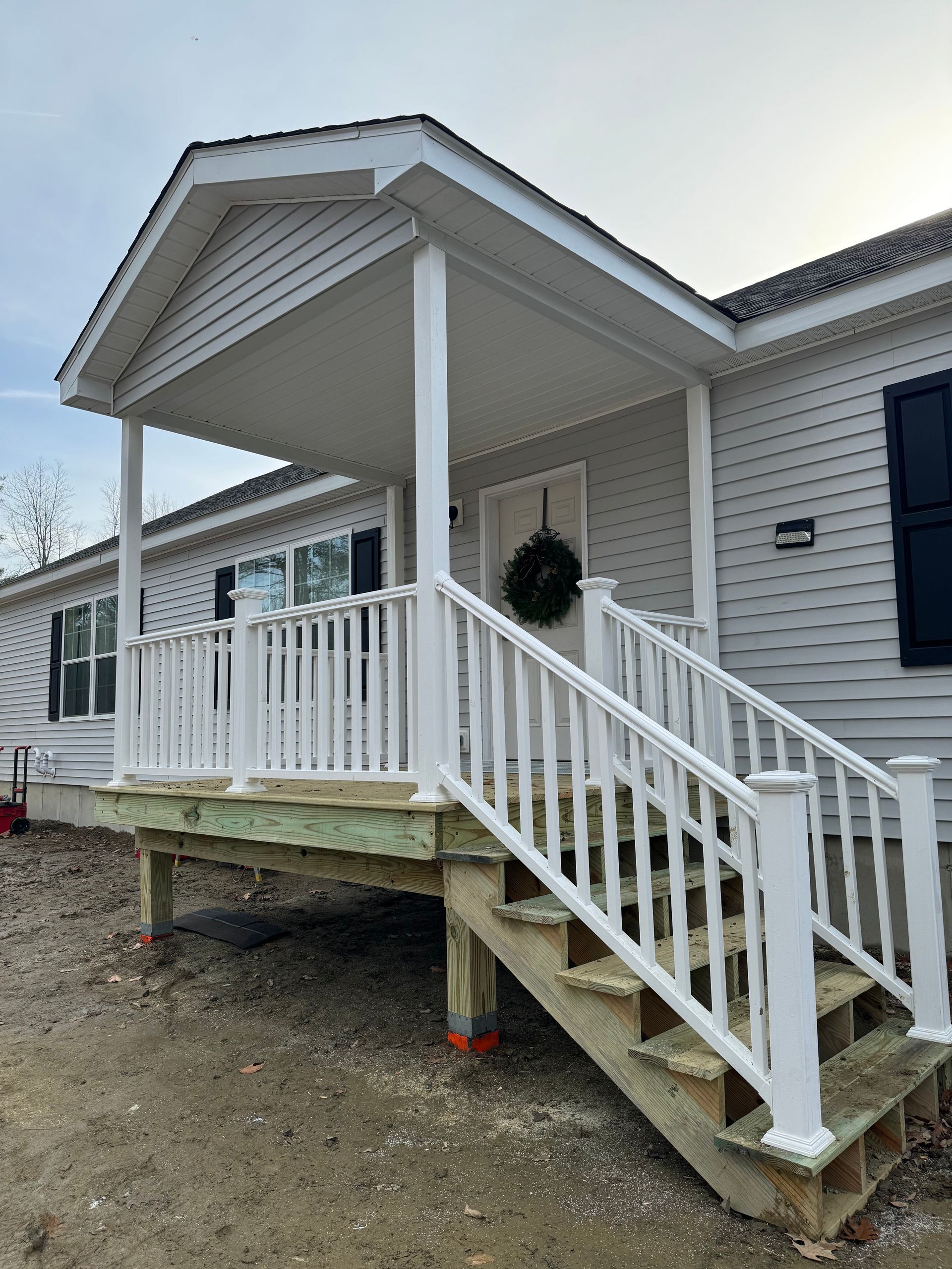 A mobile home with a porch and stairs.