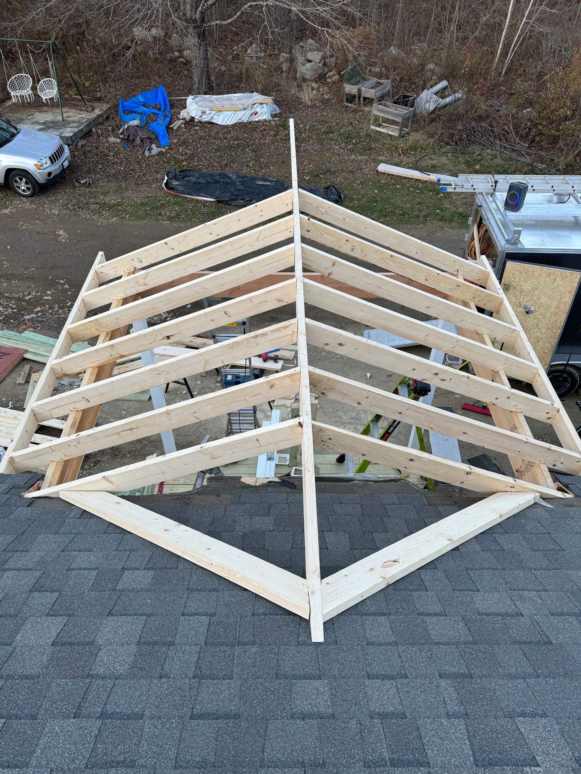 A wooden structure is being built on top of a roof.