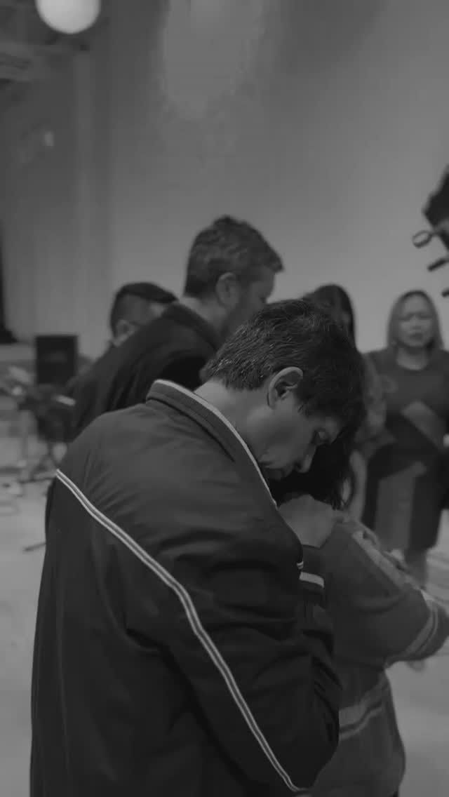 Gente bailando en una sala. Un hombre con chaqueta está boca abajo. Otras personas se ven borrosas al fondo.