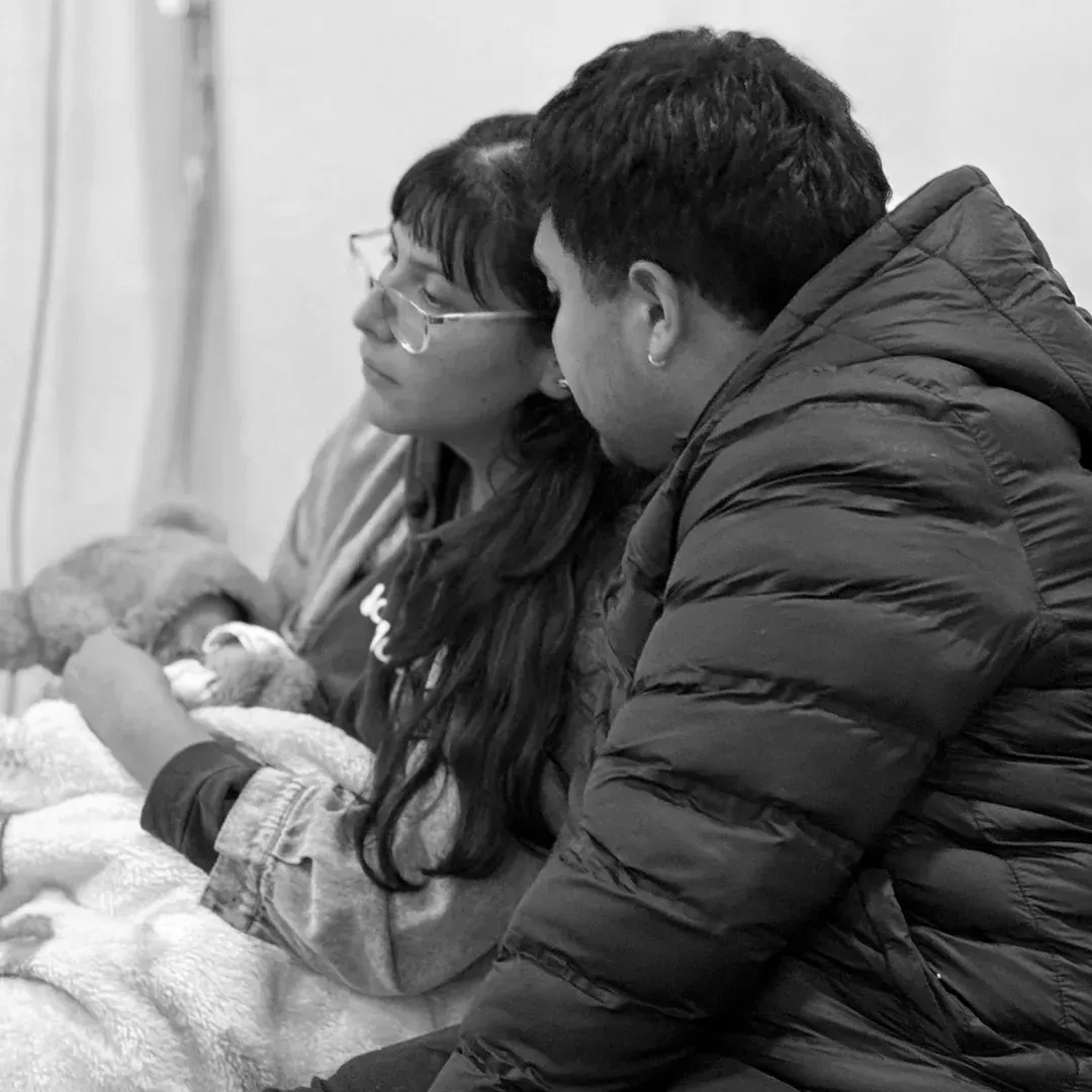 Un hombre tocando un saxofón frente a un teclista; ambos músicos están actuando.