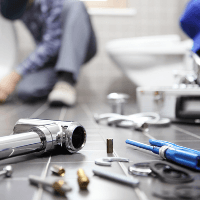 Plumbing Contractor — Plumber fixing a broken pipe In Chicago, IL
