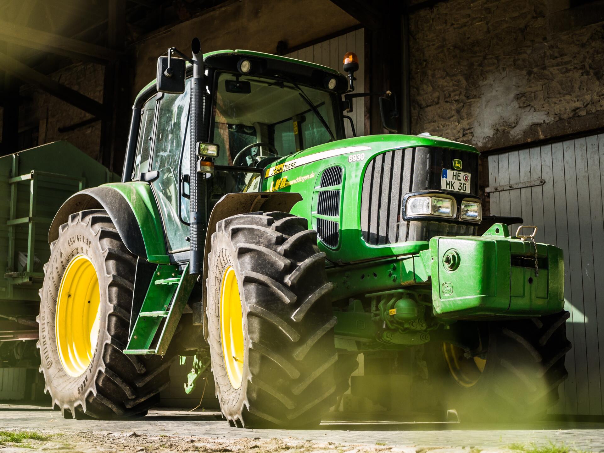 A Green and Yellow Tractor Is Parked in Front of A Building — Earthmoving Rentals Pty Ltd in Yatala, QLD