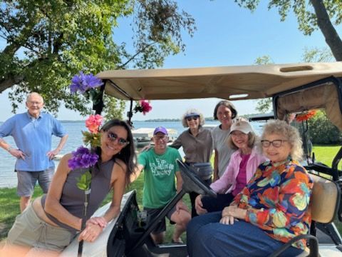 A man and a woman are sitting in chairs fishing in a lake.