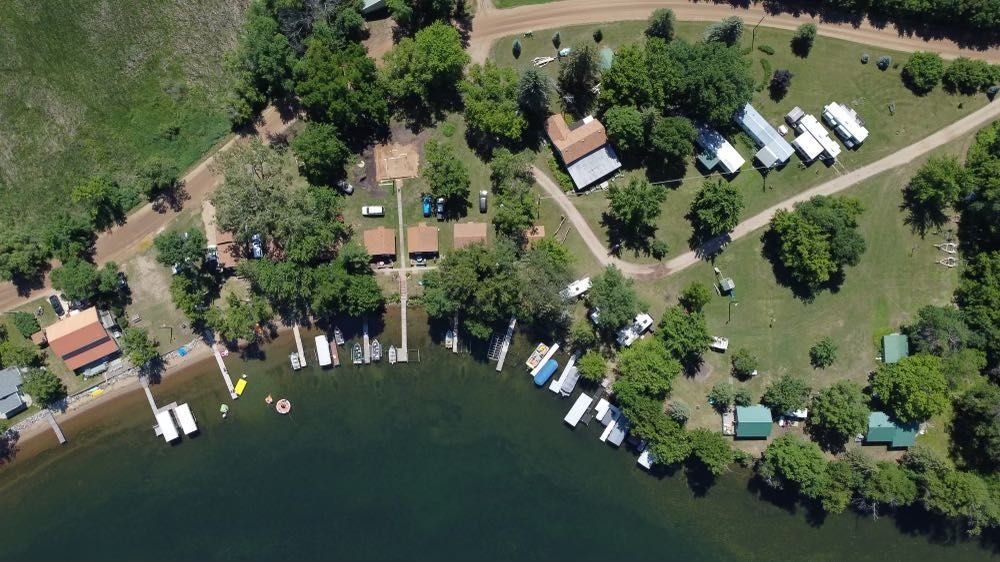 An aerial view of a lake surrounded by trees and boats.