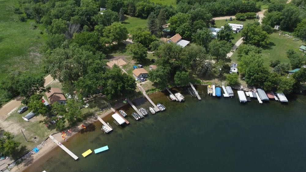 An aerial view of a lake with boats docked on the shore.
