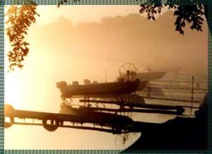 Boats are docked at a dock on a foggy day
