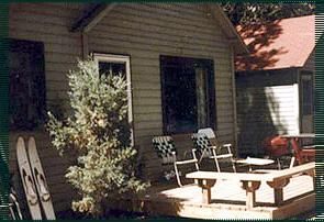 A house with a porch with chairs and skis on it