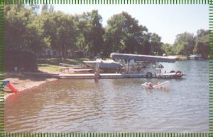 A boat is docked at a dock on a lake.