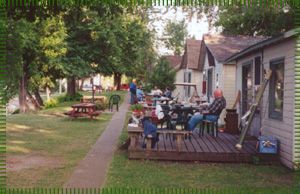 A group of people are sitting on a deck in front of a house.