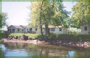 A picture of a house next to a body of water