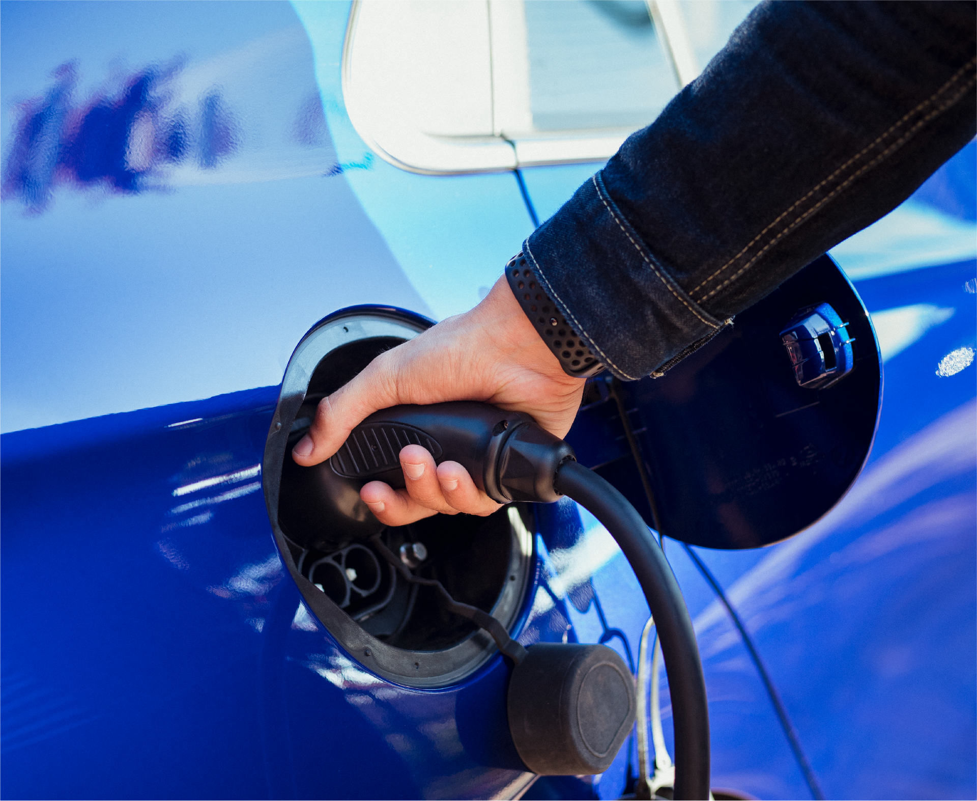 A person is charging an electric car with a charger.