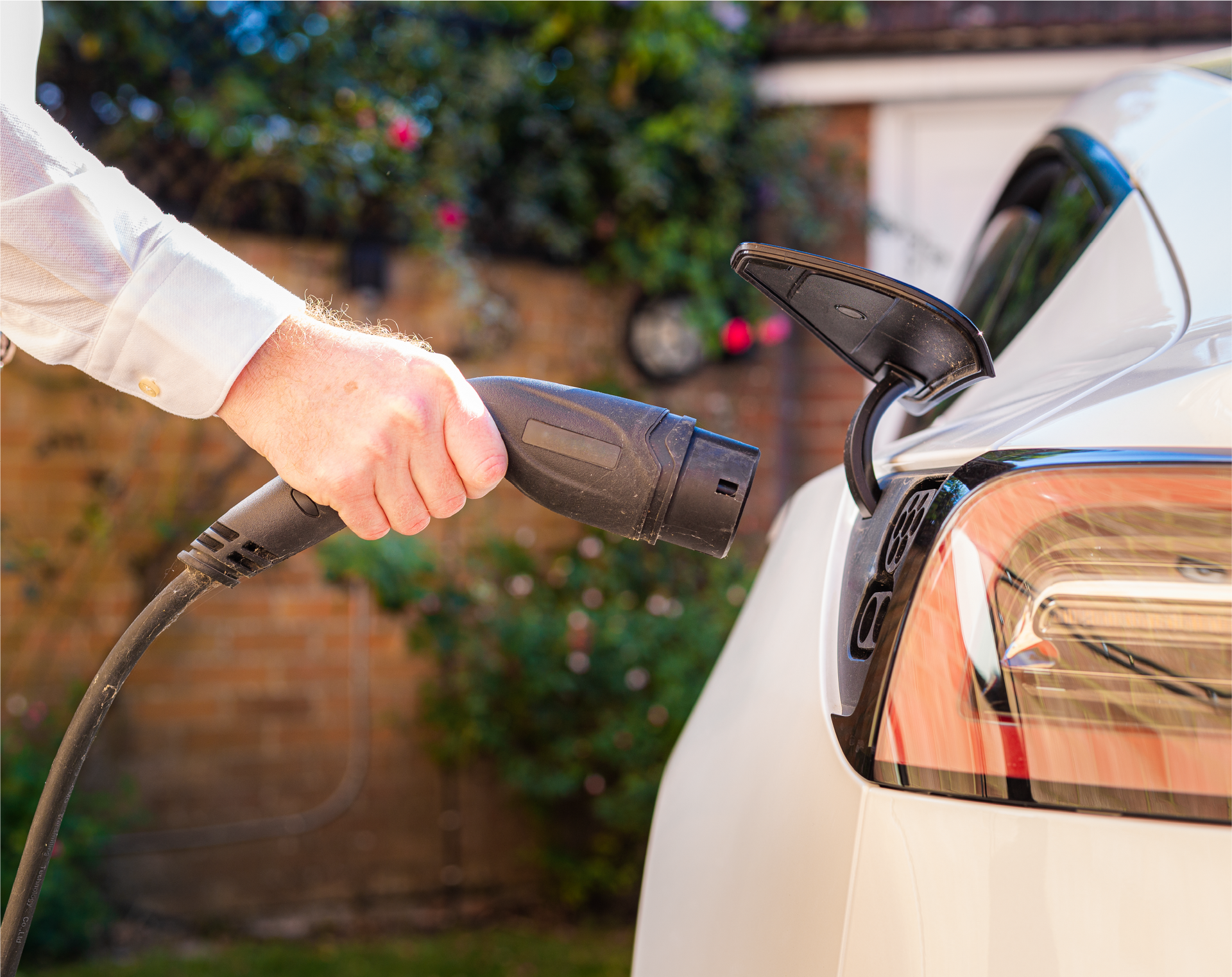 A person is charging an electric car with a charger.