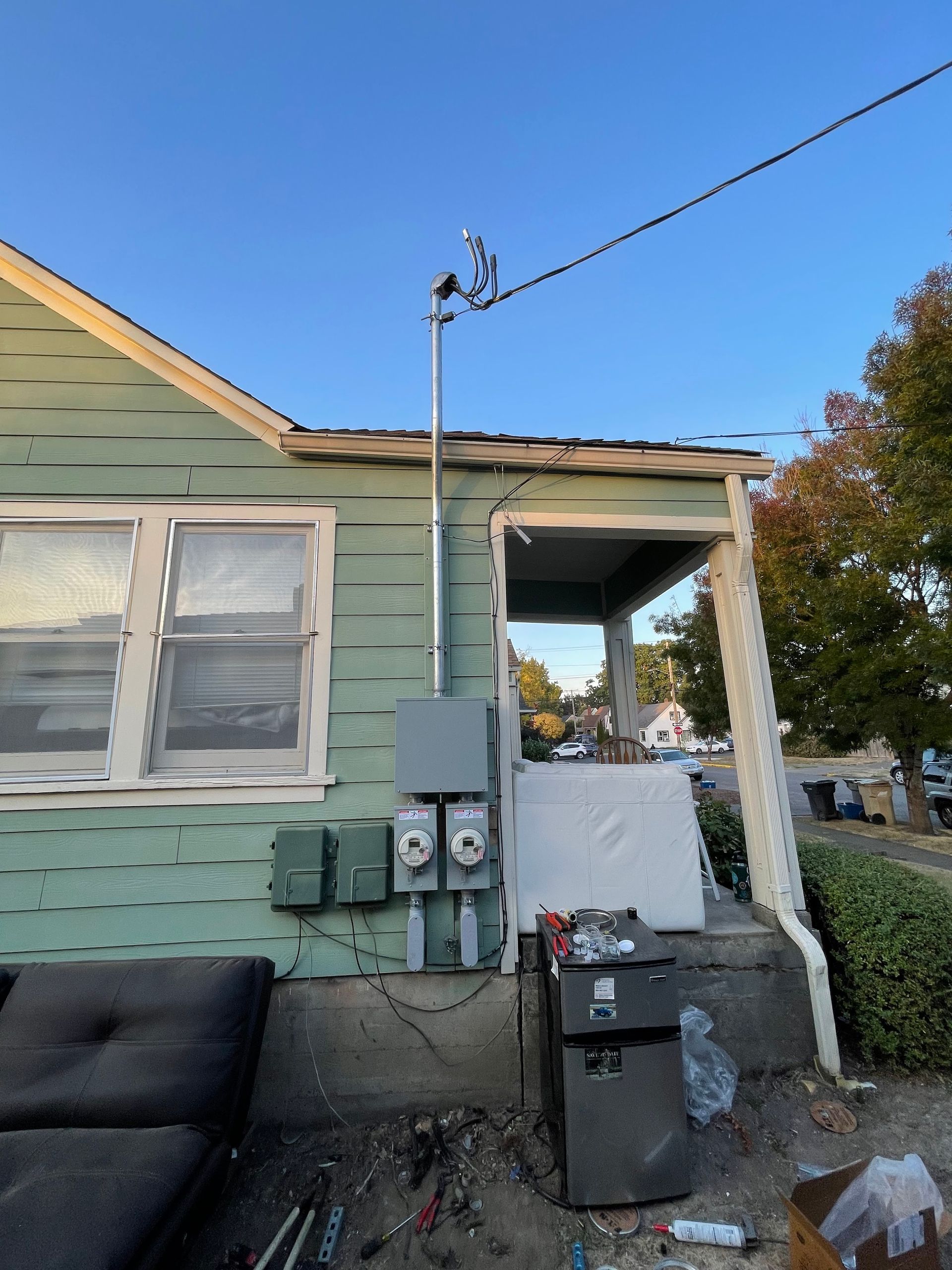 Freedom Electric Construction - A green house with a couch and a box on the ground in front of it.