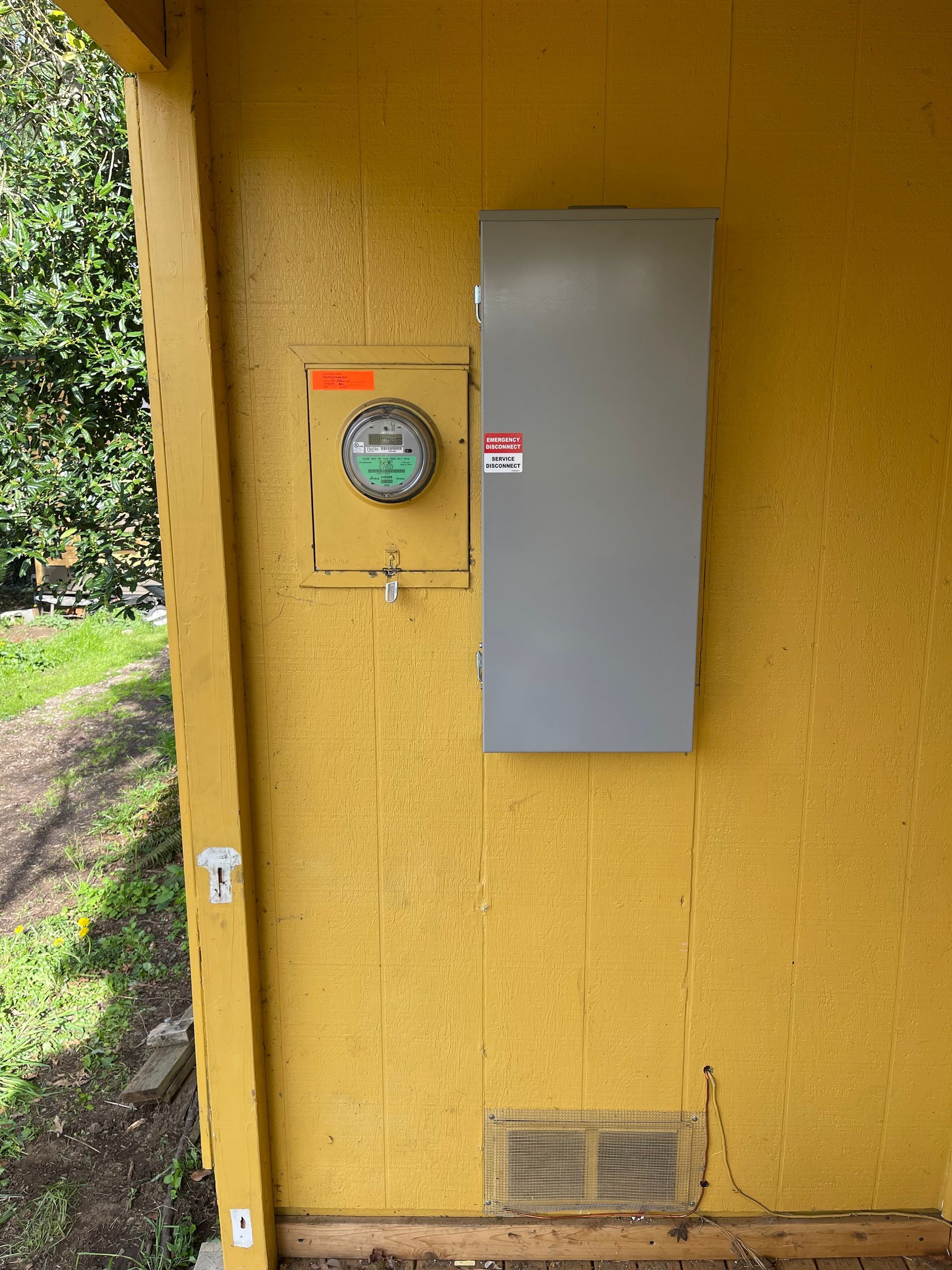 Freedom Electric Construction - A yellow wall with a meter and a box on it