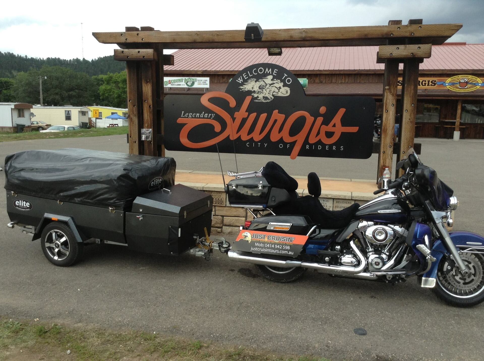 an Elite Camper Trailer parked in front of a signage