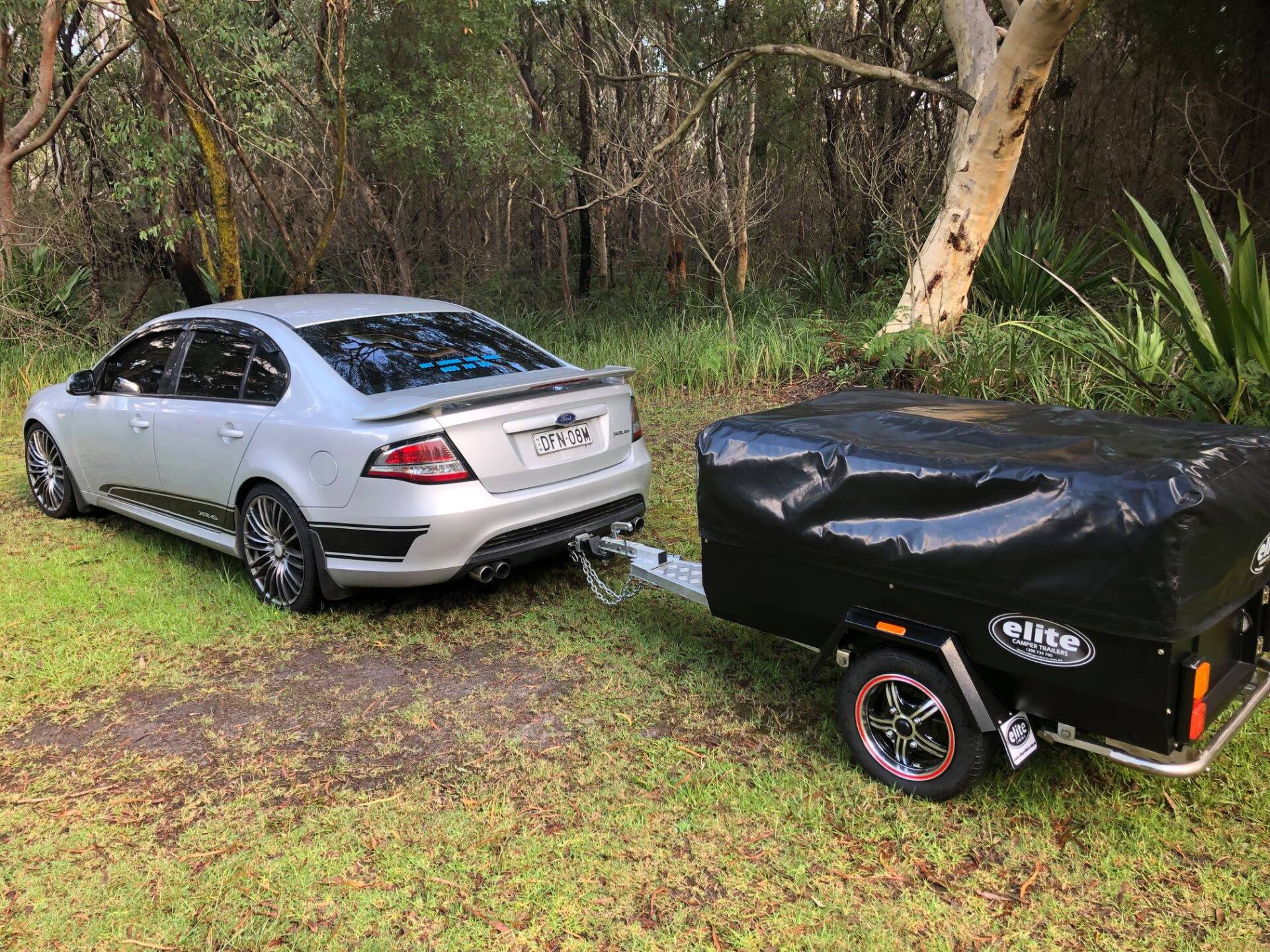 a sedan with an Elite Cargo Trailer attached to it