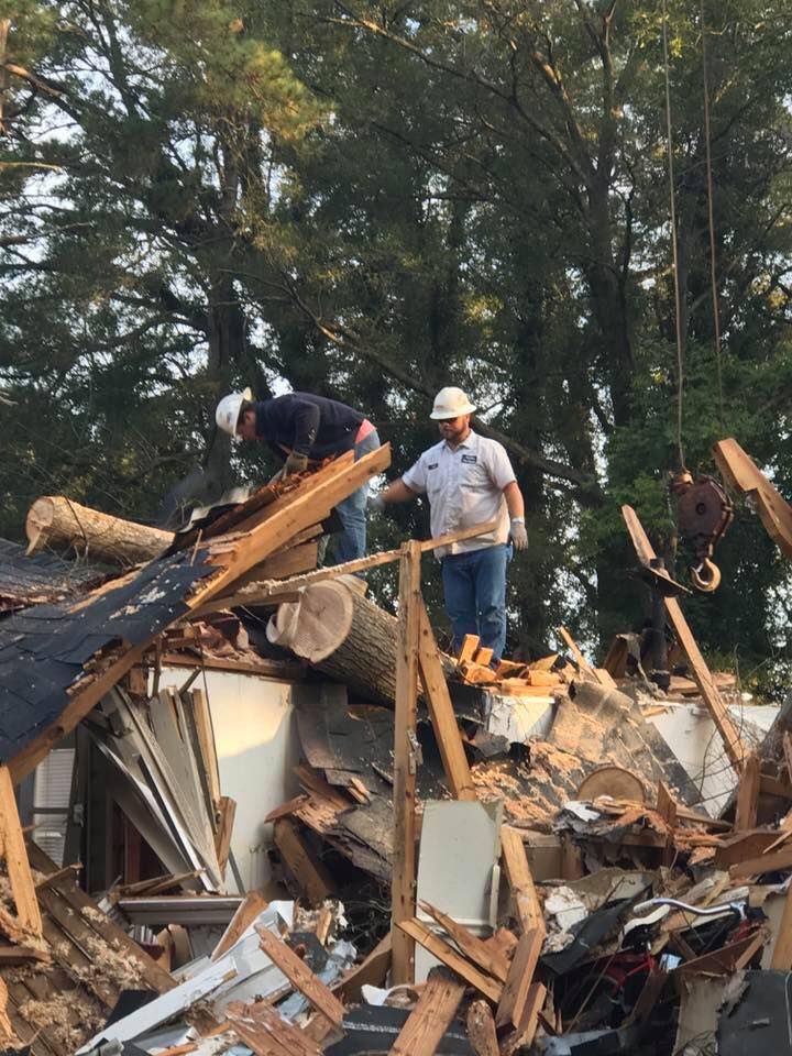 Two Men Are Standing on Top of a Pile of Rubble — Sanford, NC — Phil Stone & Sons Tree Removal