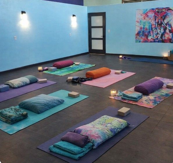 Yoga instructor guides students in a studio; poses include side bends.