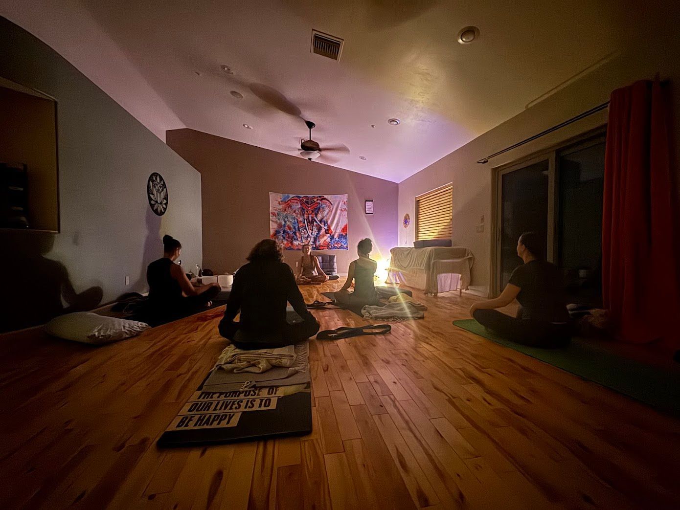 Yoga instructor guides students in a studio; poses include side bends.