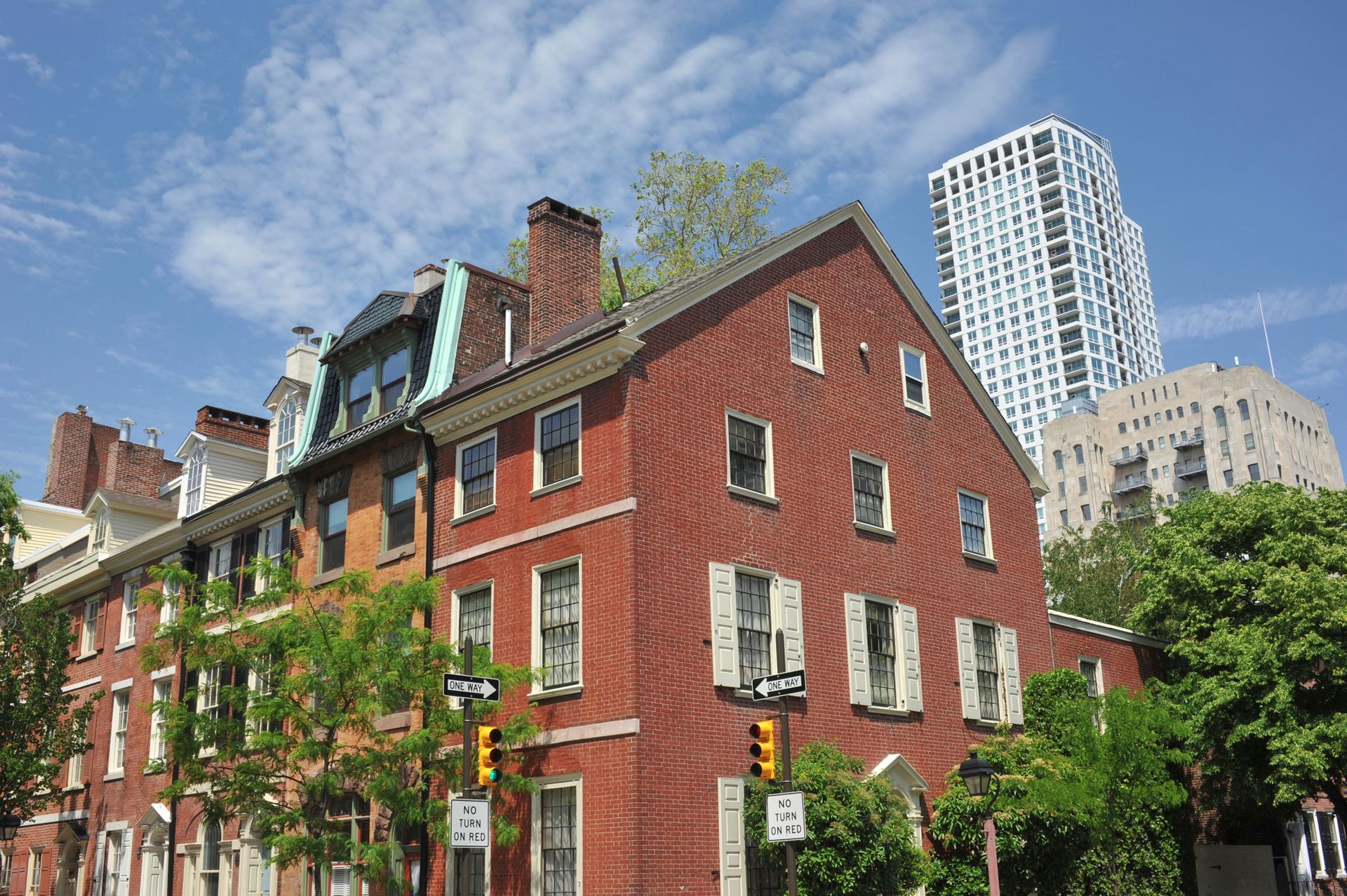 Red brick historic buildings in a city, with modern high-rise in background, blue sky overhead. Red brick historic buildings in a city, with modern high-rise in background, blue sky overhead.