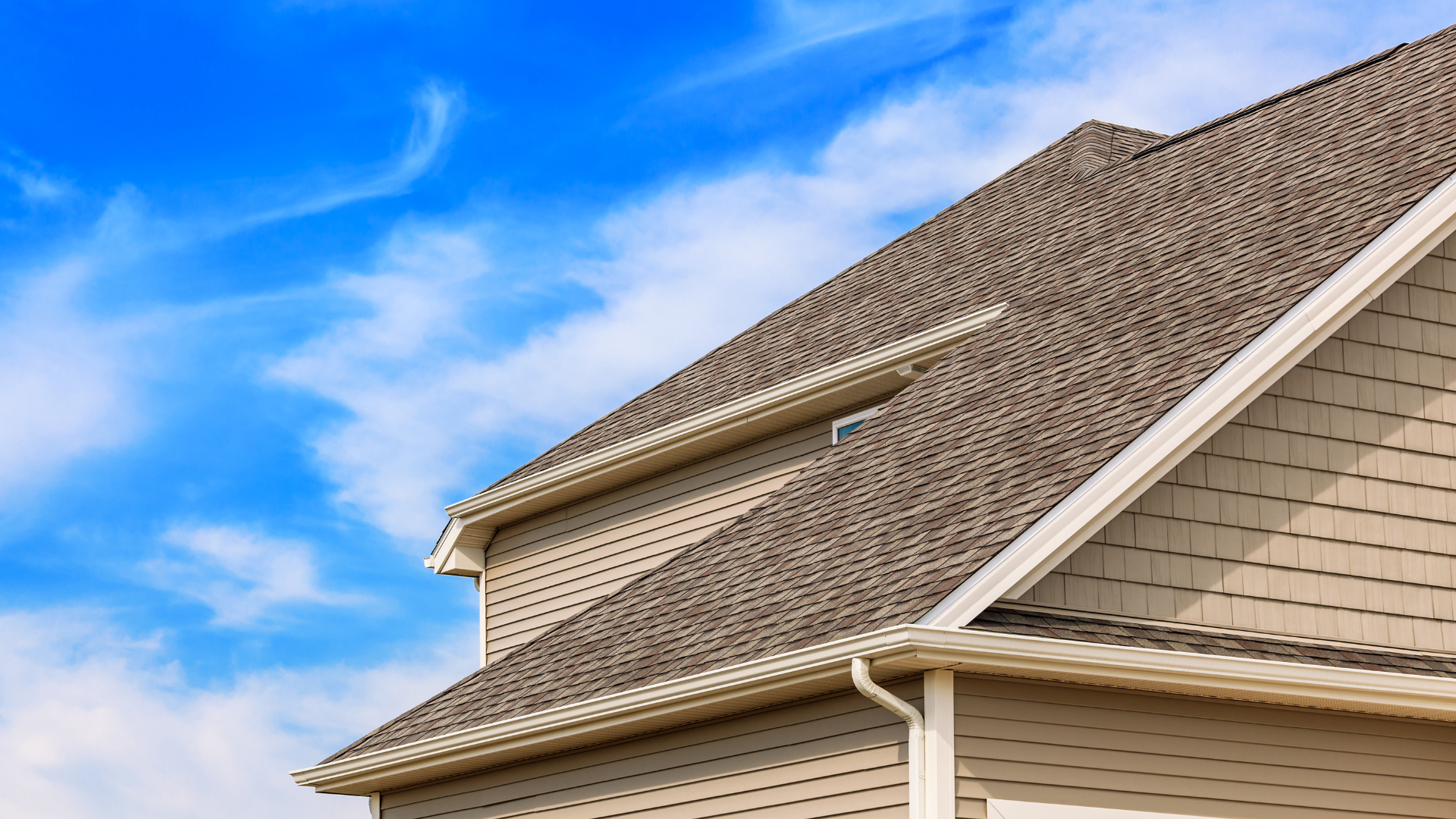 The roof of a house with a blue sky in the background.