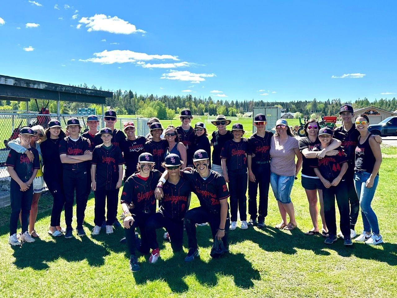 A group of people are posing for a picture in a field.