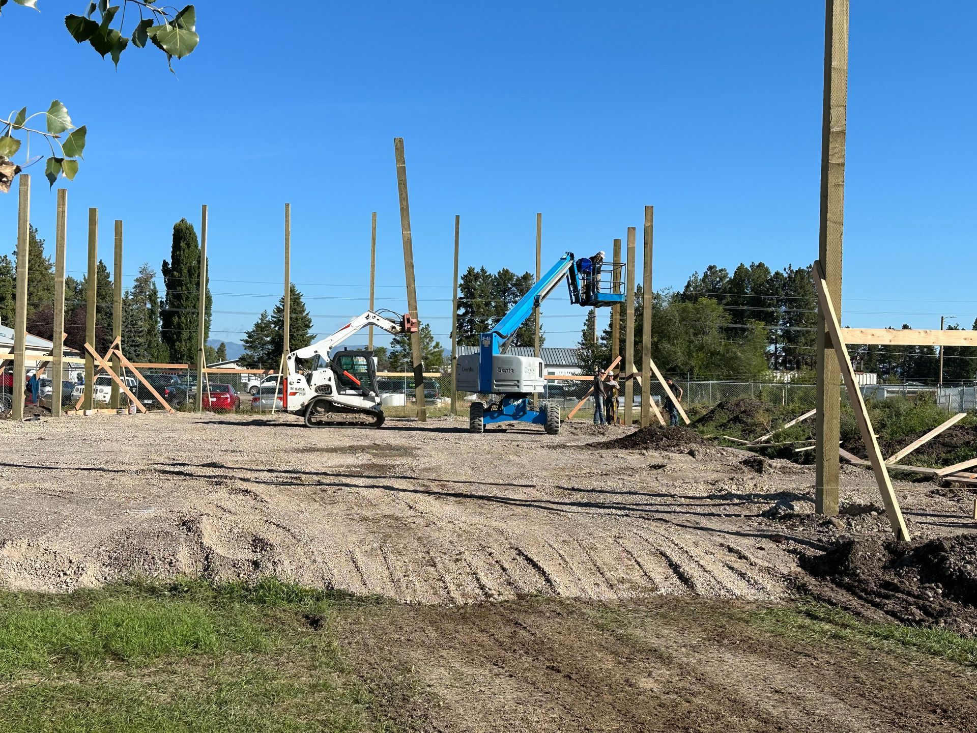 A construction site with a lot of wooden poles and a crane.
