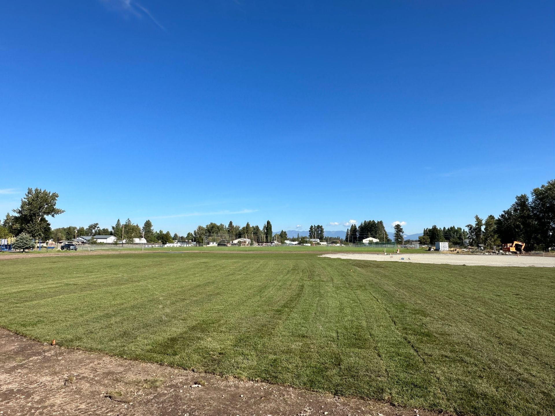 A large grassy field with a blue sky in the background.