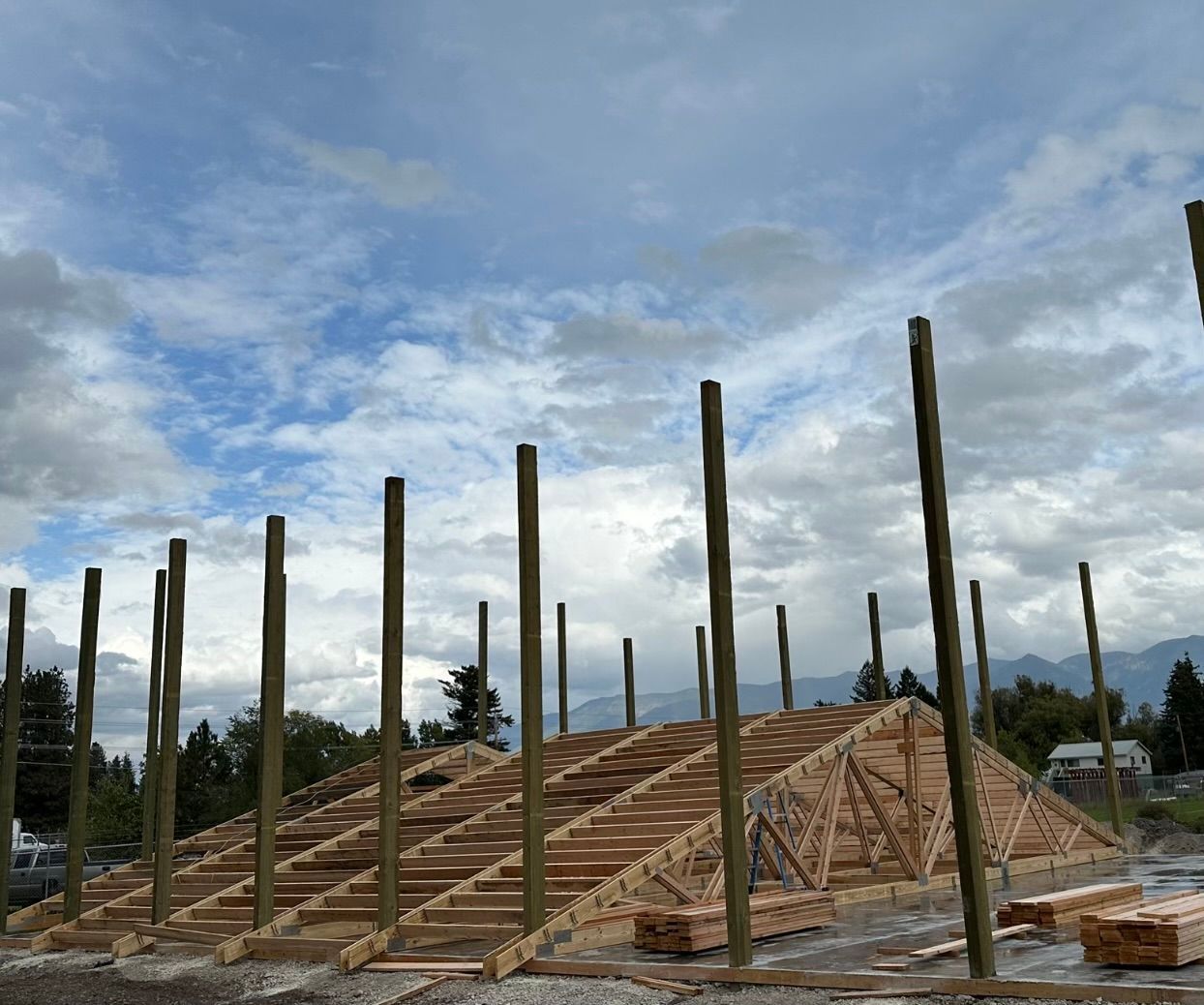 A wooden structure is being built with a cloudy sky in the background