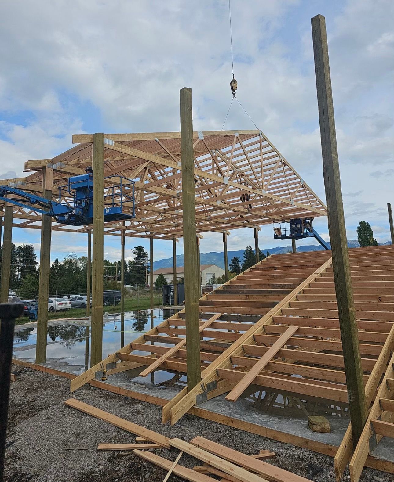 A large wooden structure is being built with a crane.
