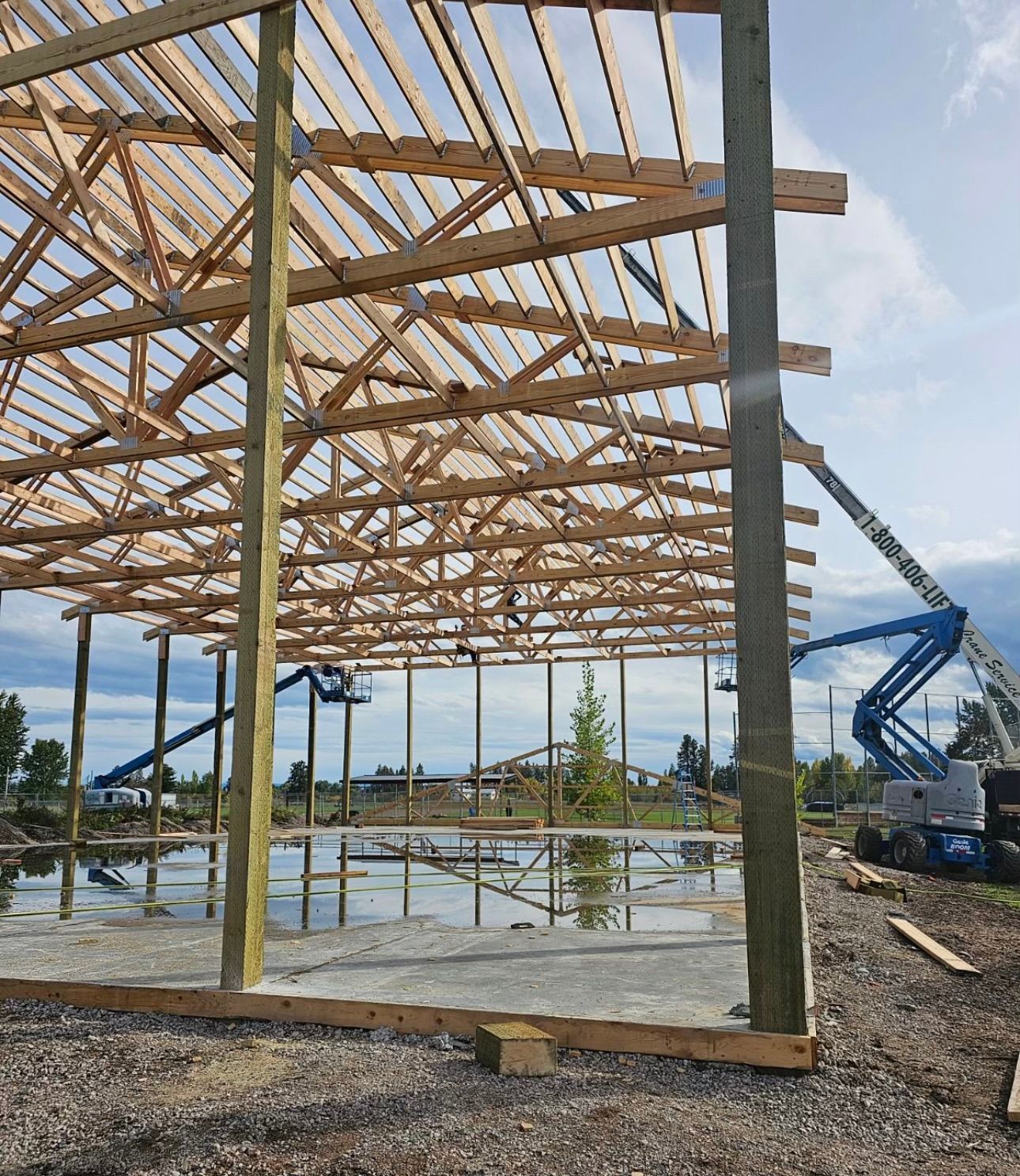A large wooden structure is being built with a crane in the background.