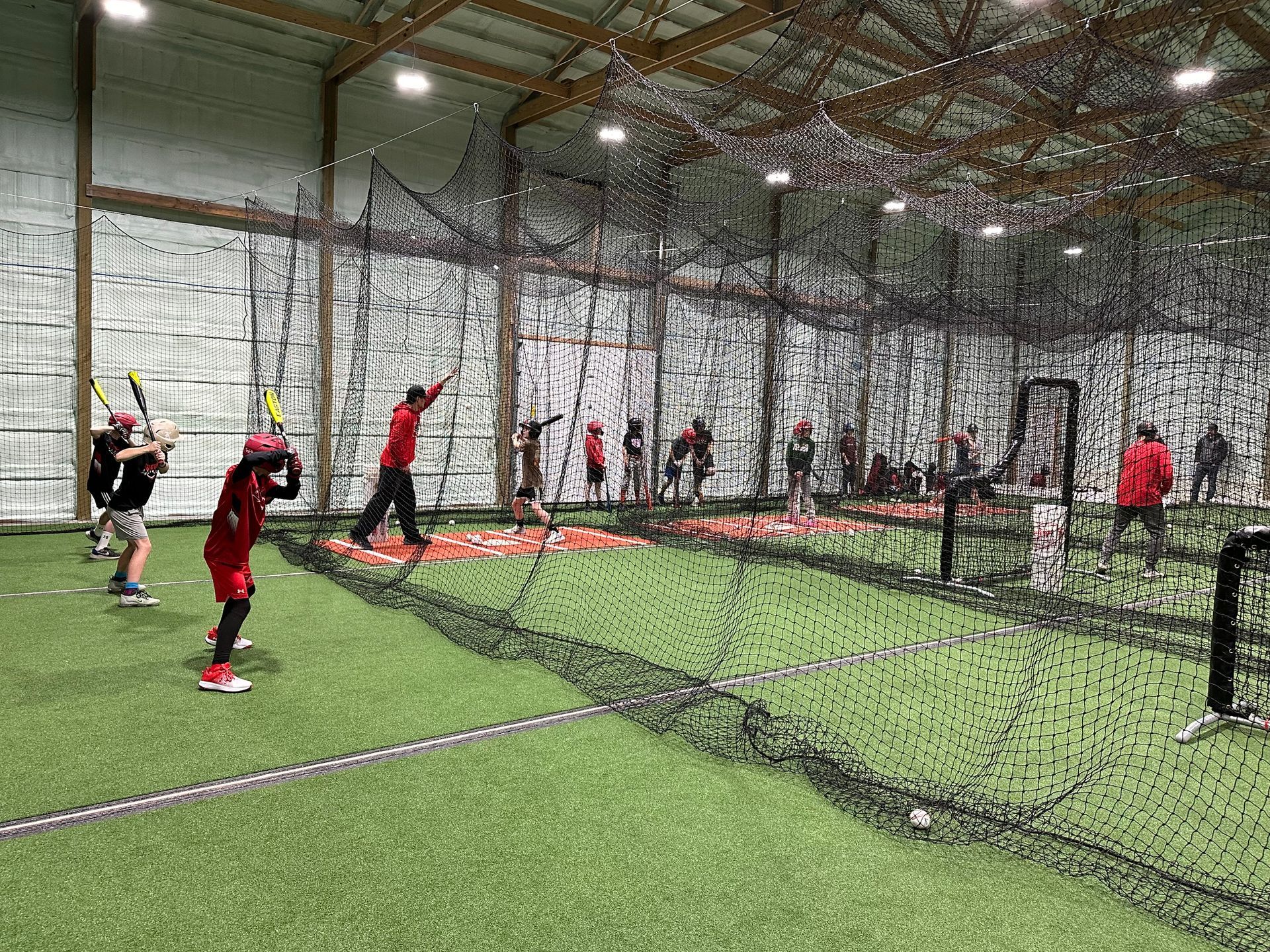 A group of people are playing baseball in an indoor stadium.