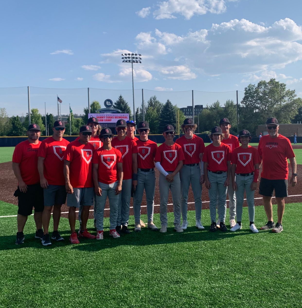 A group of baseball players are posing for a picture on a field