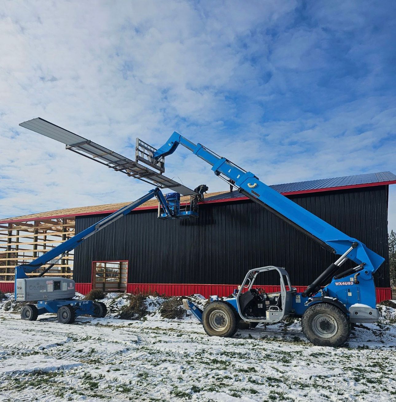 A blue forklift is parked in front of a building under construction