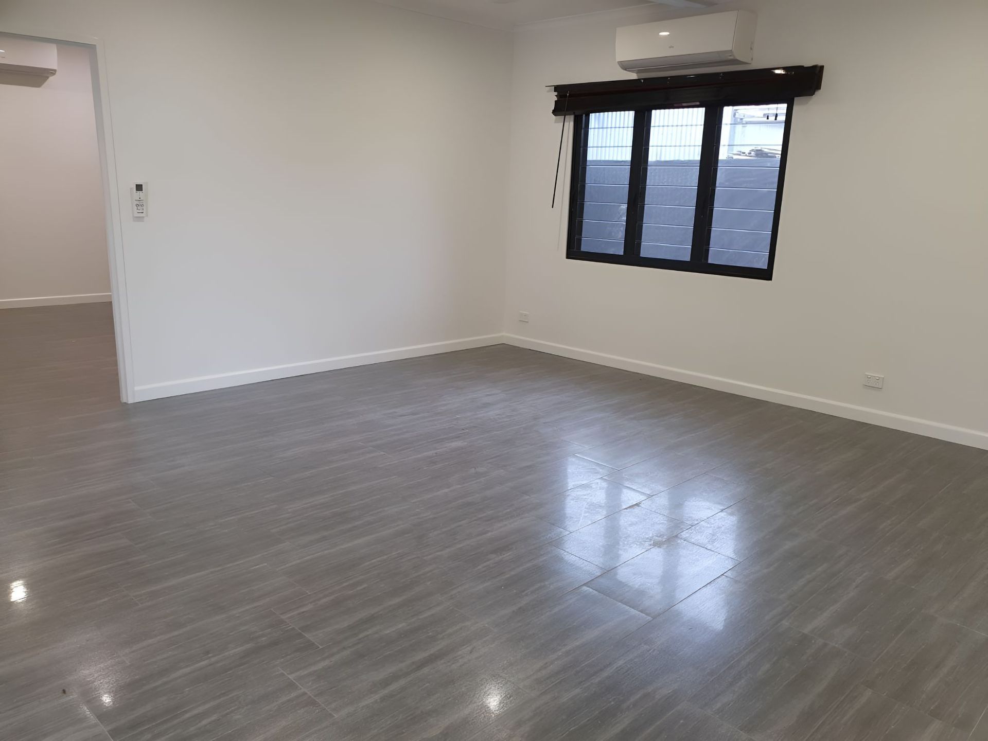 An Empty Living Room with A Tiled Floor and A Window — Regina's Cleaning Group Pty Ltd In Lee Point, NT