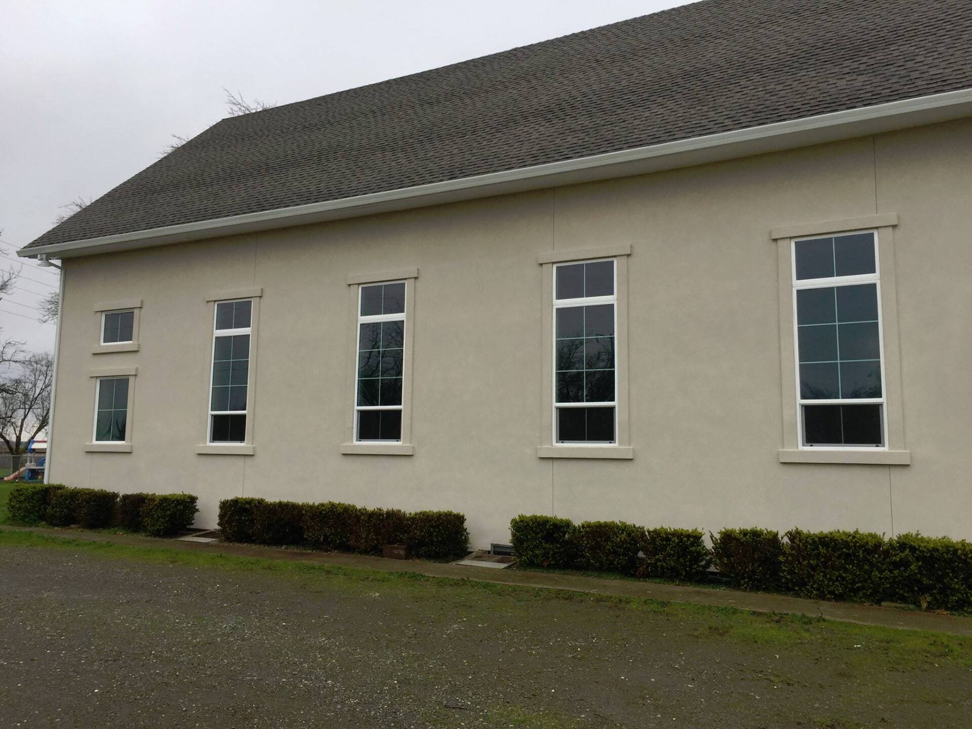 A white building with a roof and a lot of windows