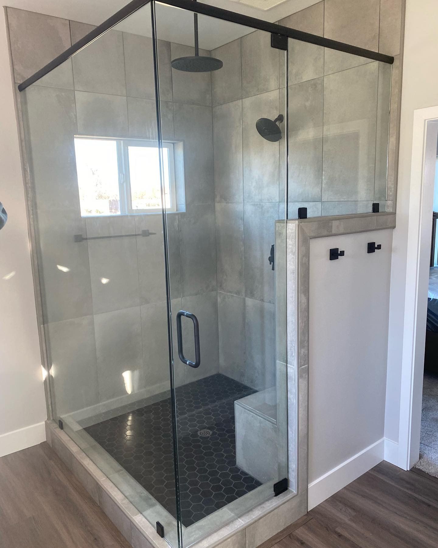 A bathroom with a glass shower door and a shower head.