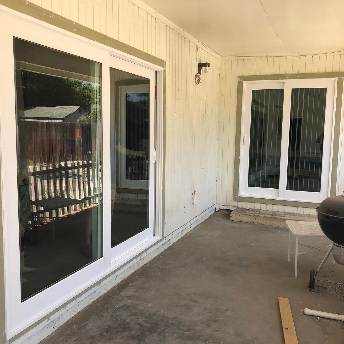 A porch with sliding glass doors and a grill.