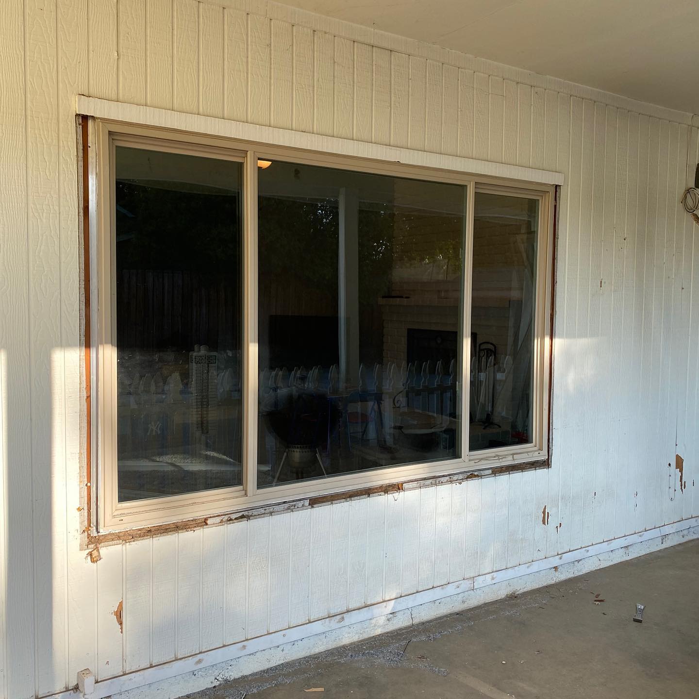 A large window on the side of a white house.
