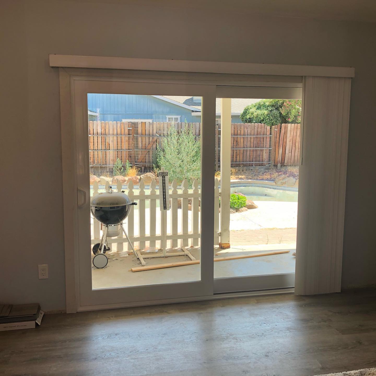 A living room with a sliding glass door leading to a backyard.
