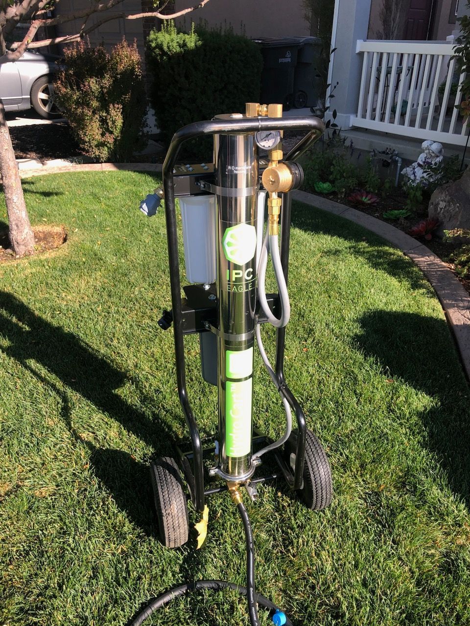 A water de-ionizer machine is sitting on a cart in the grass