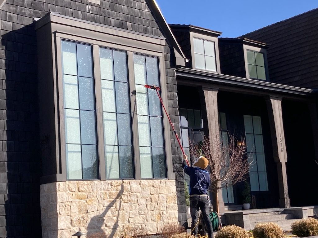 A man is cleaning the windows of a house