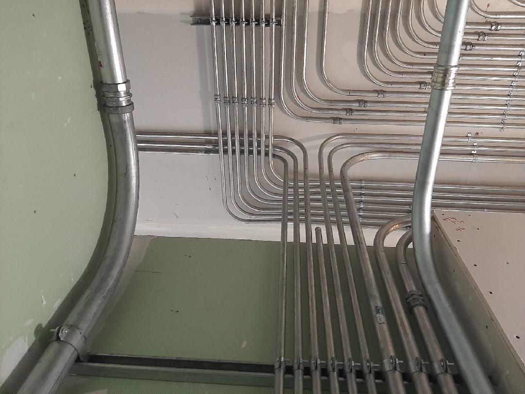 Galvanized electrical conduit pipes installed on a ceiling.