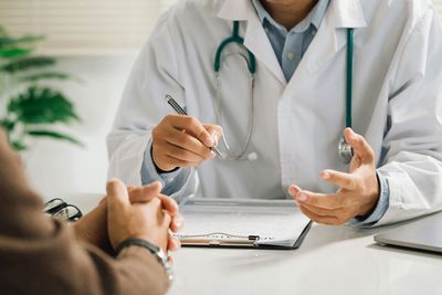Doctor speaking with a patient at a desk Doctor speaking with a patient at a desk
